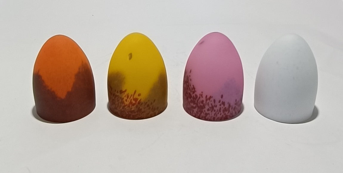 Lámpara de mesa con base metálica y pantalla de cristal de color.