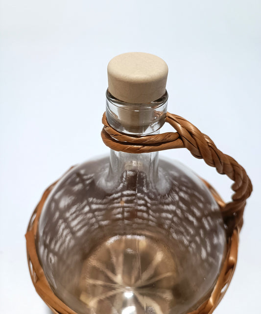 Botella de vidrio de 2 litros con asa y forro de mimbre.