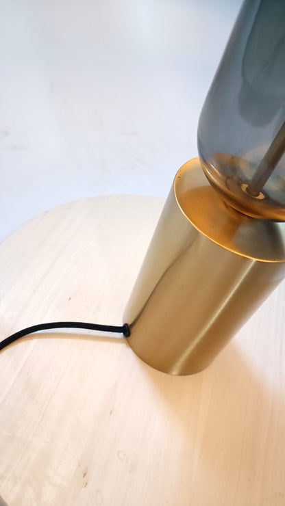 Base de lámpara en metal dorado y cristal gris.