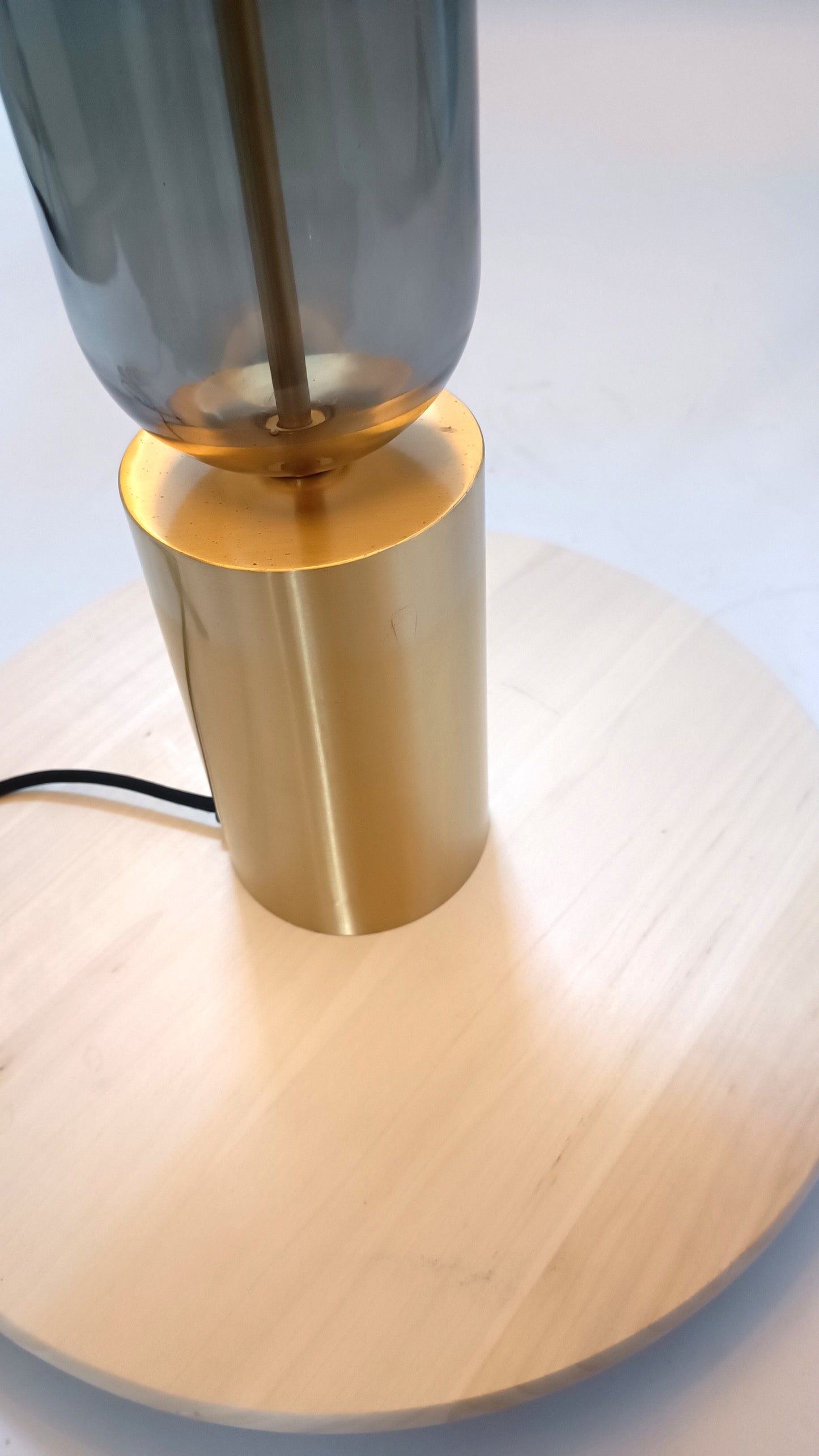 Base de lámpara en metal dorado y cristal gris.