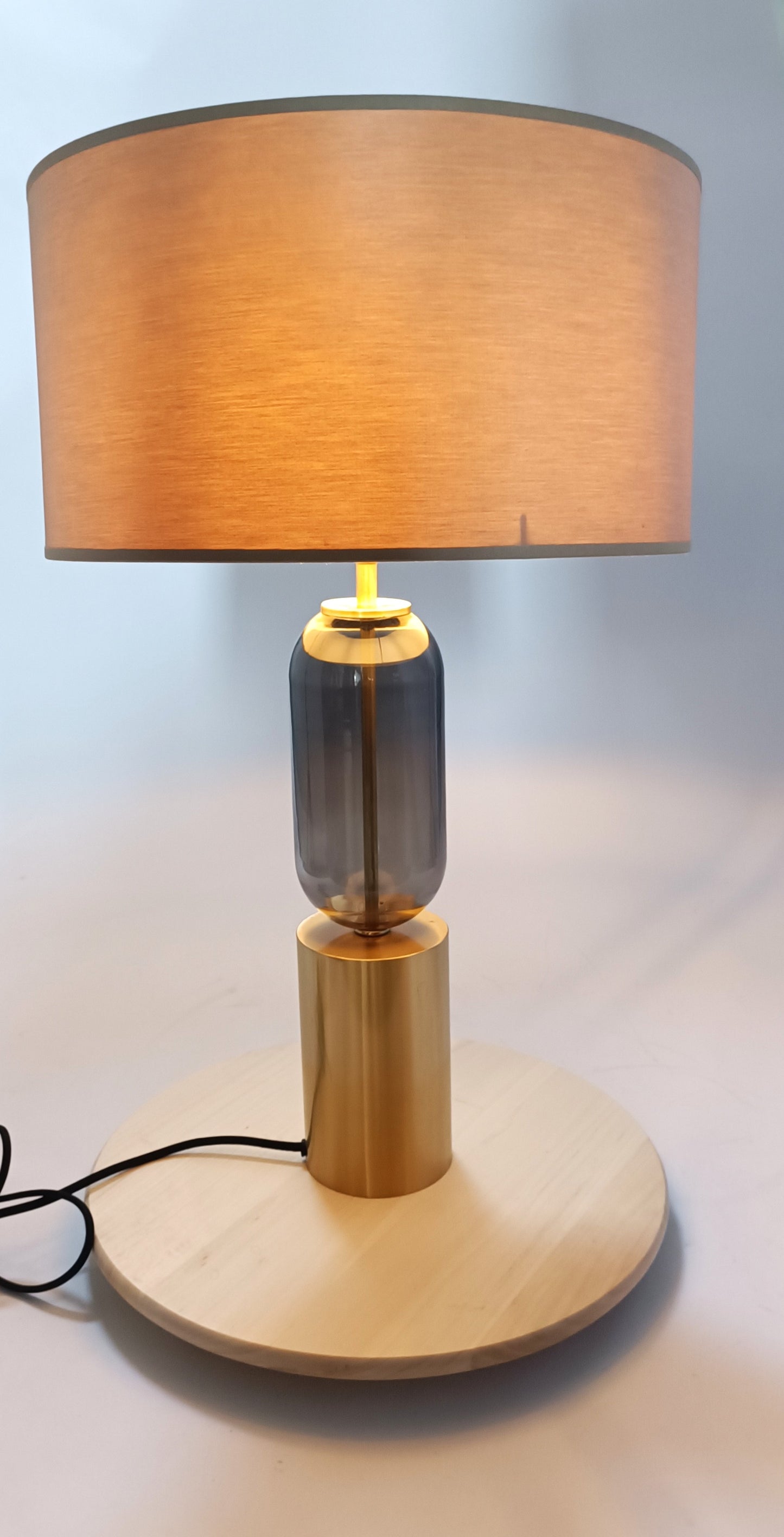 Base de lámpara en metal dorado y cristal gris.