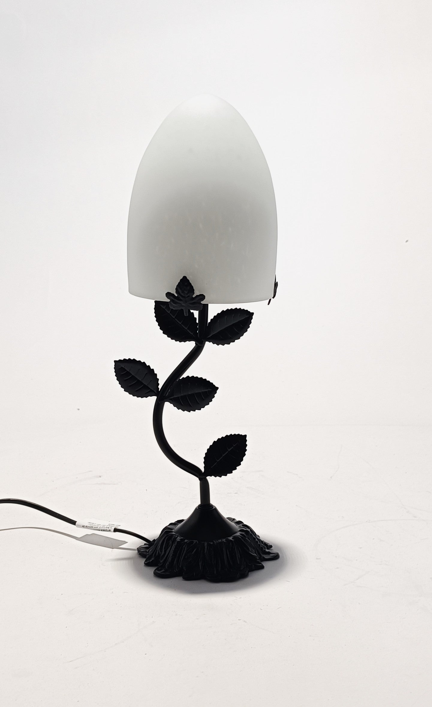 Lámpara de mesa con base metálica y pantalla de cristal de color.