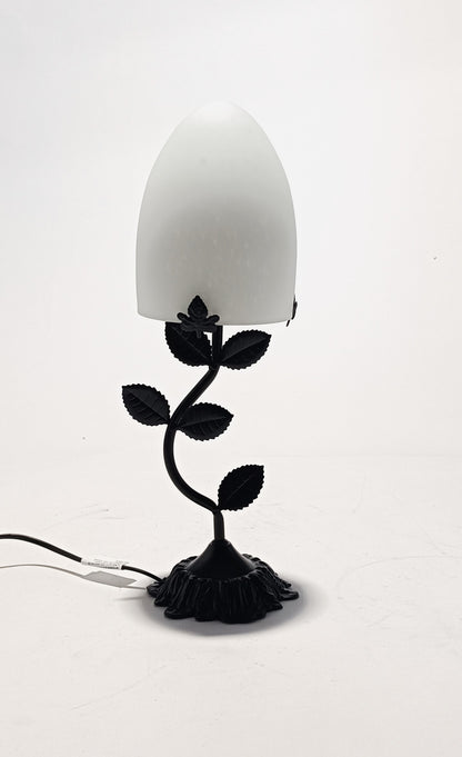 Lámpara de mesa con base metálica y pantalla de cristal de color.