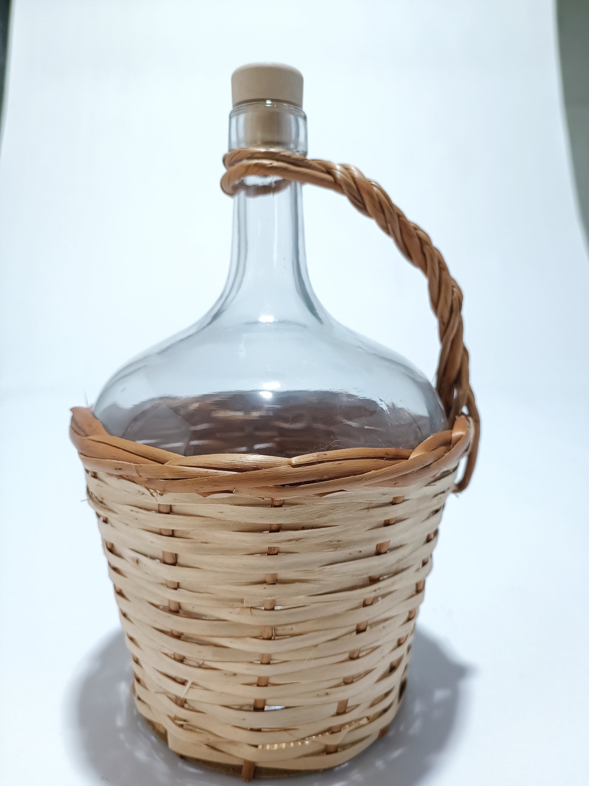 Botella de vidrio de 2 litros con asa y forro de mimbre.