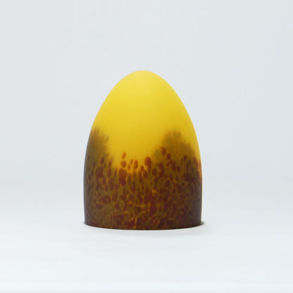 Lámpara de mesa con base metálica y pantalla de cristal de color.