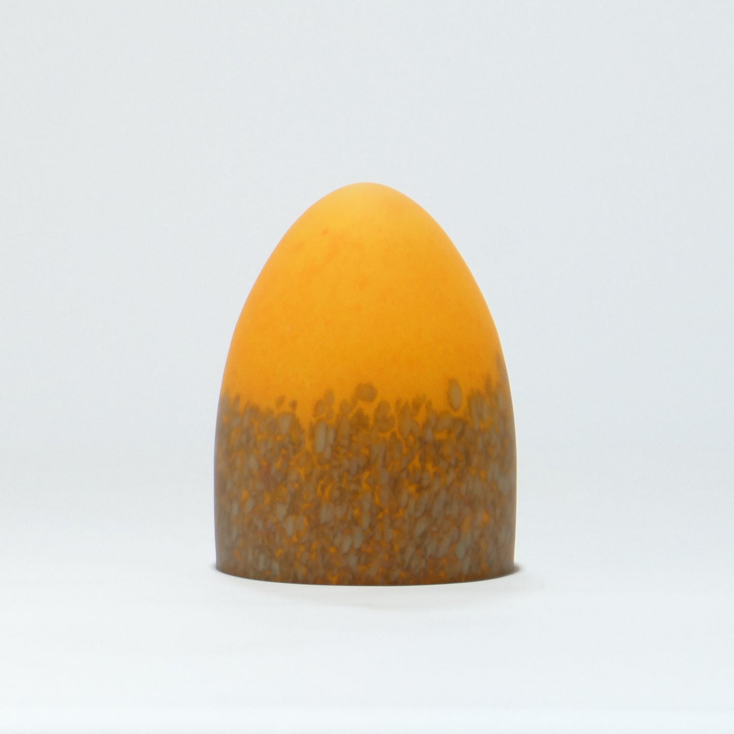 Lámpara de mesa con base metálica y pantalla de cristal de color.