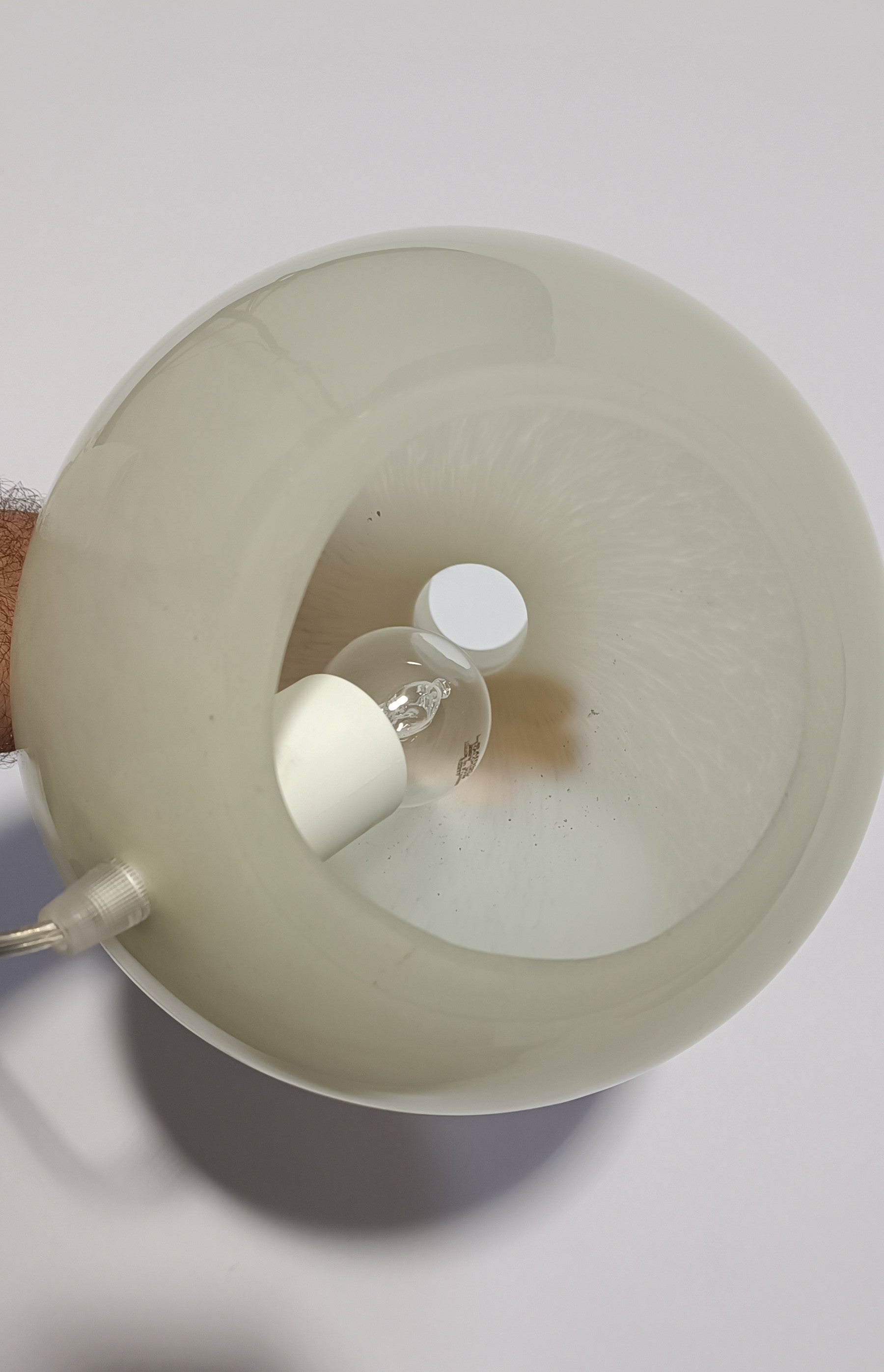 Vista superior do candeeiro Halo Brando aceso, com brilho suave visível na superfície.