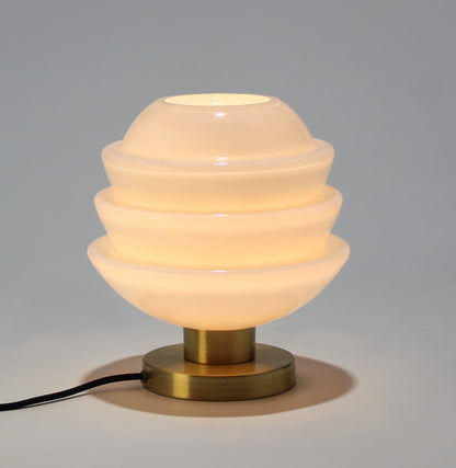 Lámpara de mesa de cristal opalino con base metálica.