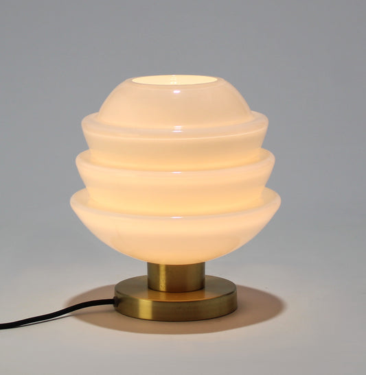 Lámpara de mesa de cristal opalino con base metálica.